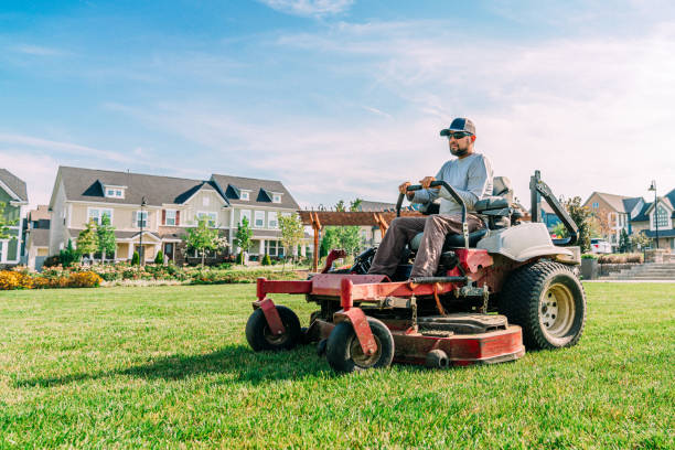 Landscaper on a riding mower at a residential property